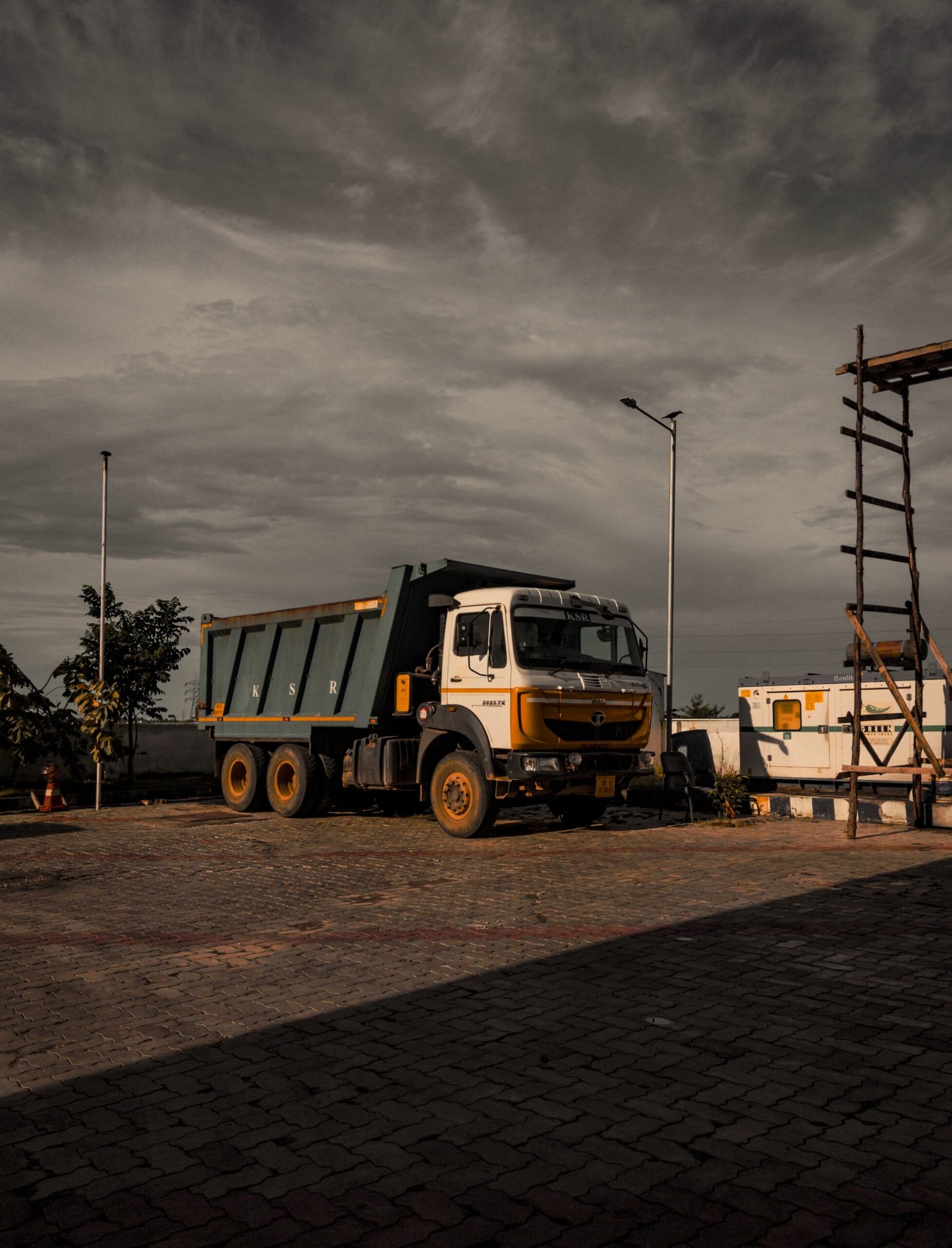 a dump truck parked in a parking lot under a cloudy sky